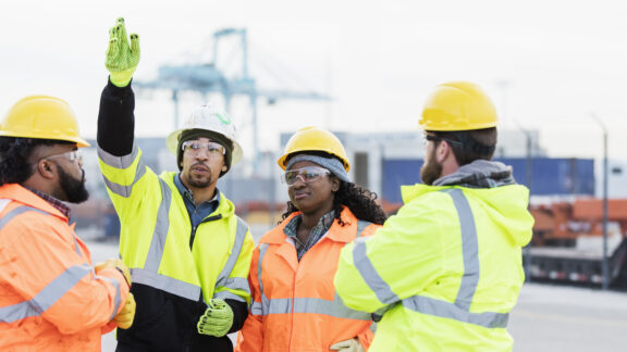Multi-ethnic dock workers at shipping port