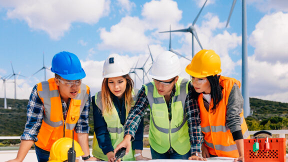 Young engineers and workers having a meeting at wind farm