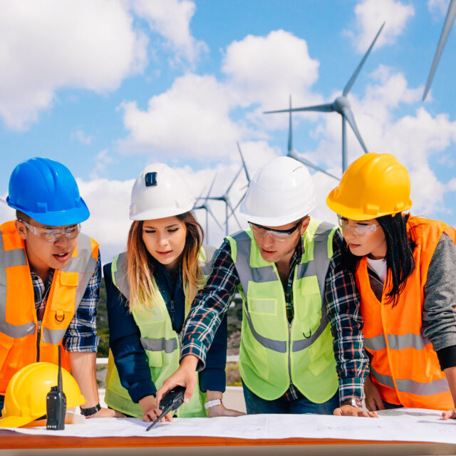 Young engineers and workers having a meeting at wind farm