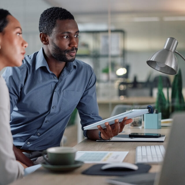 Collaboration, computer and tablet with business people in office together for planning or project management. Feedback, teamwork or technology with employee man and woman in workplace for research